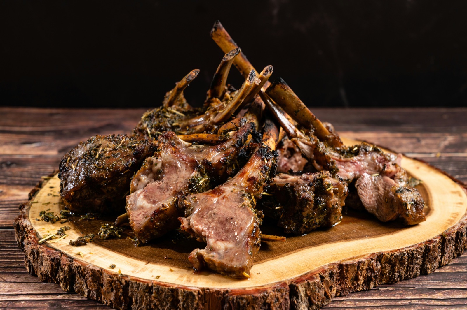 Grillade lammkotletter med rosmarin på ett träbord